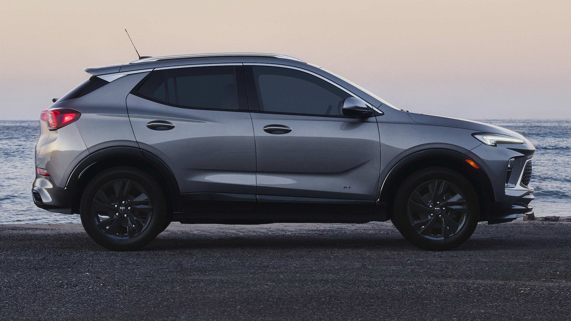A gray Buick Encore GX in profile parked at the head of a beach