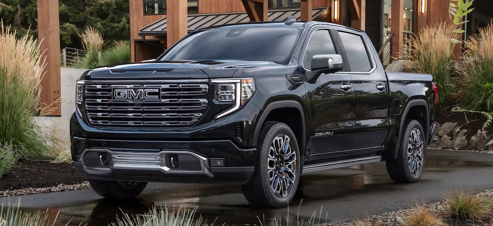 A black GMC Sierra 1500 pickup truck parked in a driveway
