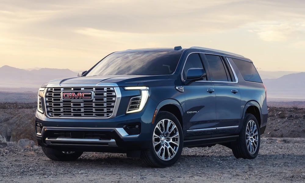 A dark blue 2027 GMC Yukon SUV at twilight