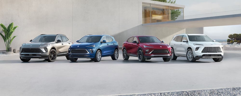 Four Buick SUVs parked in front of a gray concrete building